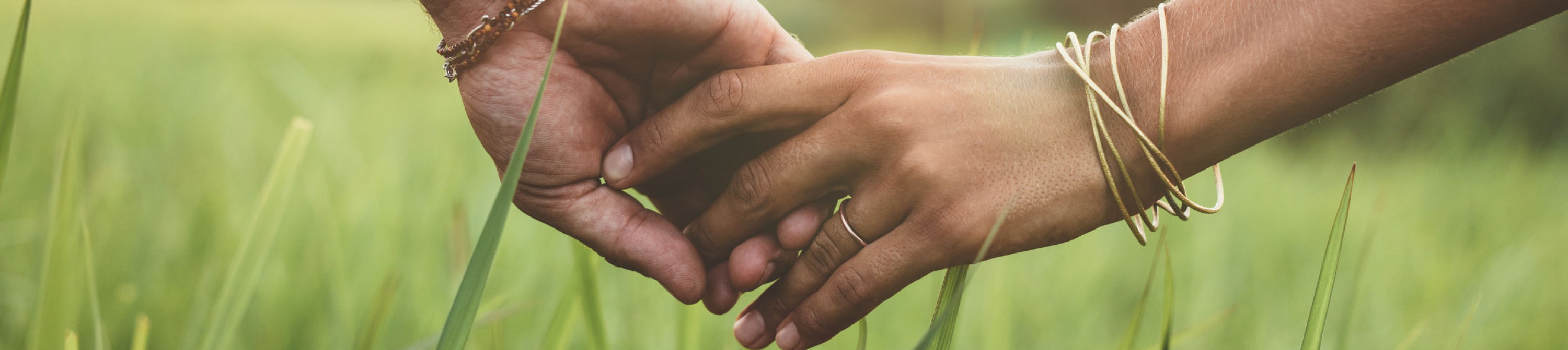 Paar Hand in Hand gehend über Wiese, Liebe, Vertrauen, Harmonie